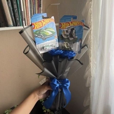 Ramo con 2 carritos Hot Wheels y rosas azules en papel negro con moño azul